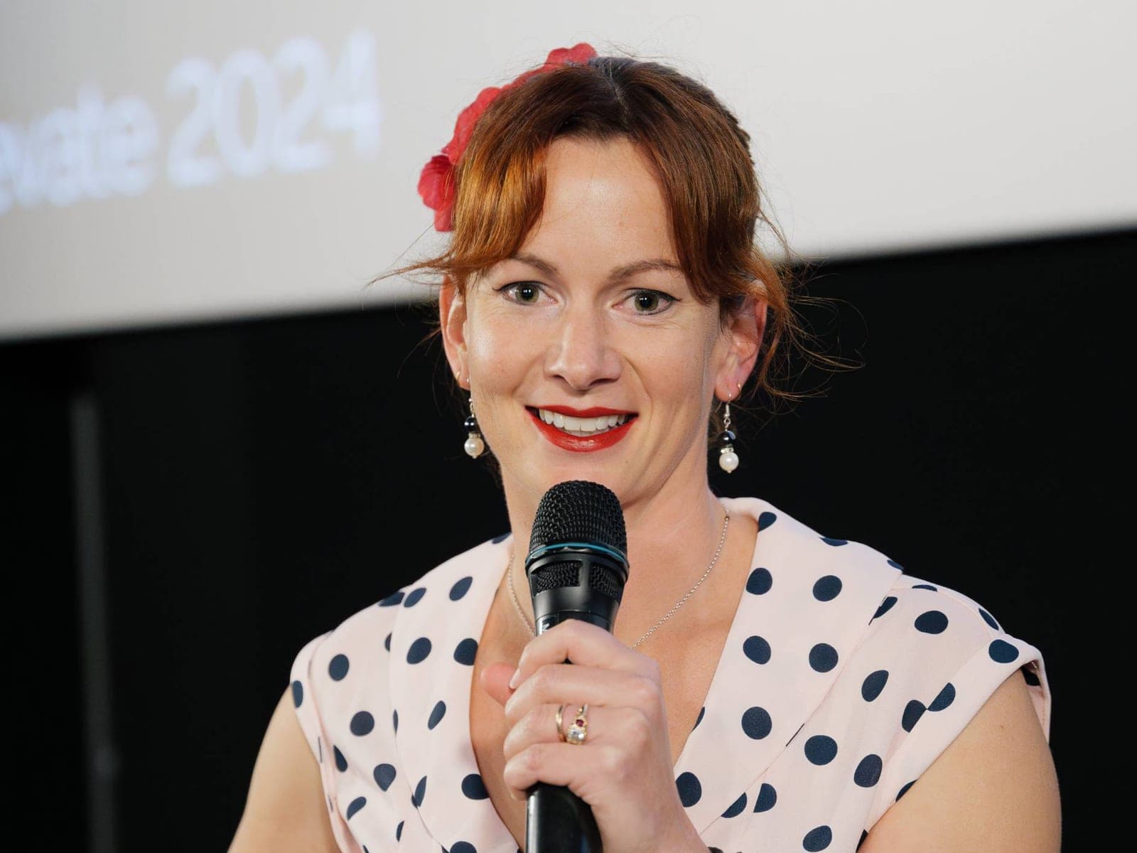 Belinda Beatty hosting an event, microphone in hand