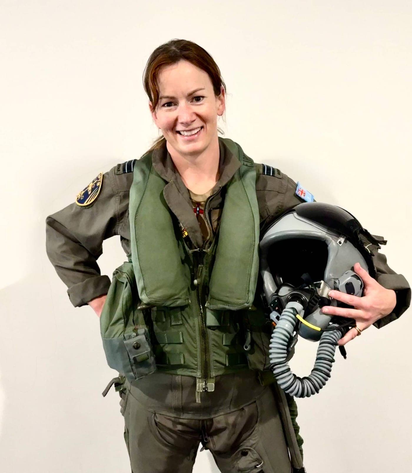 Belinda Beatty in flight gear, carrying her helmet